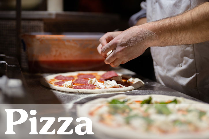 Pizzabäcker belegt eine Pizza